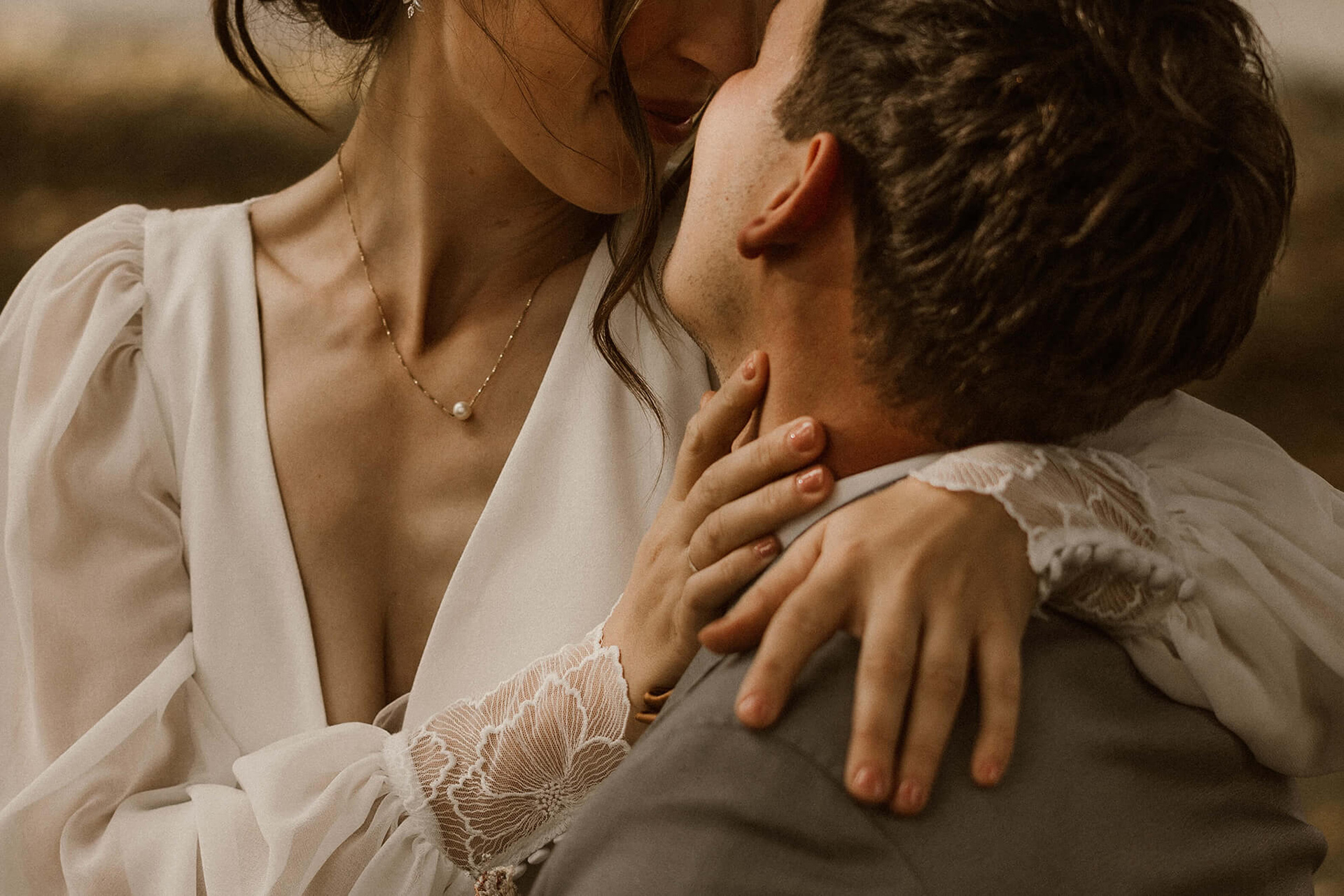 Braut küsst Bräutigam und hat ihre Hand an der Seite