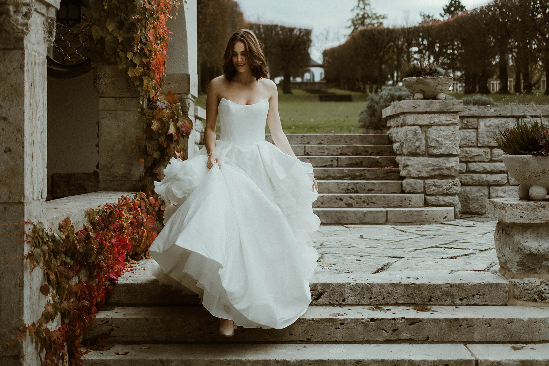 Braut läuft die Treppe herunter mit sehr hübschen weißem Kleid